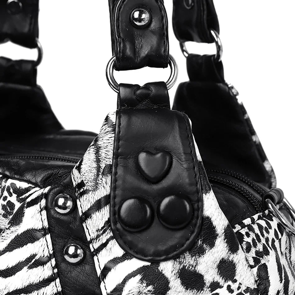 Close-up of a black and white leopard print PU leather tote bag with adjustable strap details.
