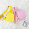 A yellow and pink nylon crossbody bag for kids lying on a white fluffy surface.