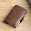 A brown leather double layer ID card holder wallet resting on a light wooden surface.