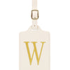 Étiquette de bagage en cuir crème rectangulaire avec un W brodé en or et un clip métallique argenté.