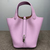 A light purple genuine leather bucket bag with a vertical zipper closure and a contrasting brown lining.
