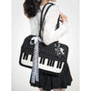 A woman is holding a black and white musical note embroidery crossbody bag with a piano print.