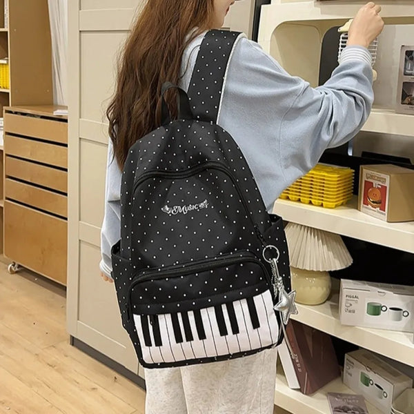 Una persona sostiene una mochila negra de lunares con un teclado de piano blanco en una tienda.