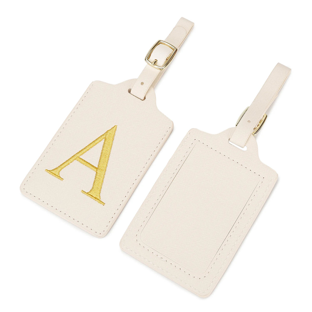 Étiquette de bagage en cuir beige clair avec un A brodé en or et une sangle en cuir.