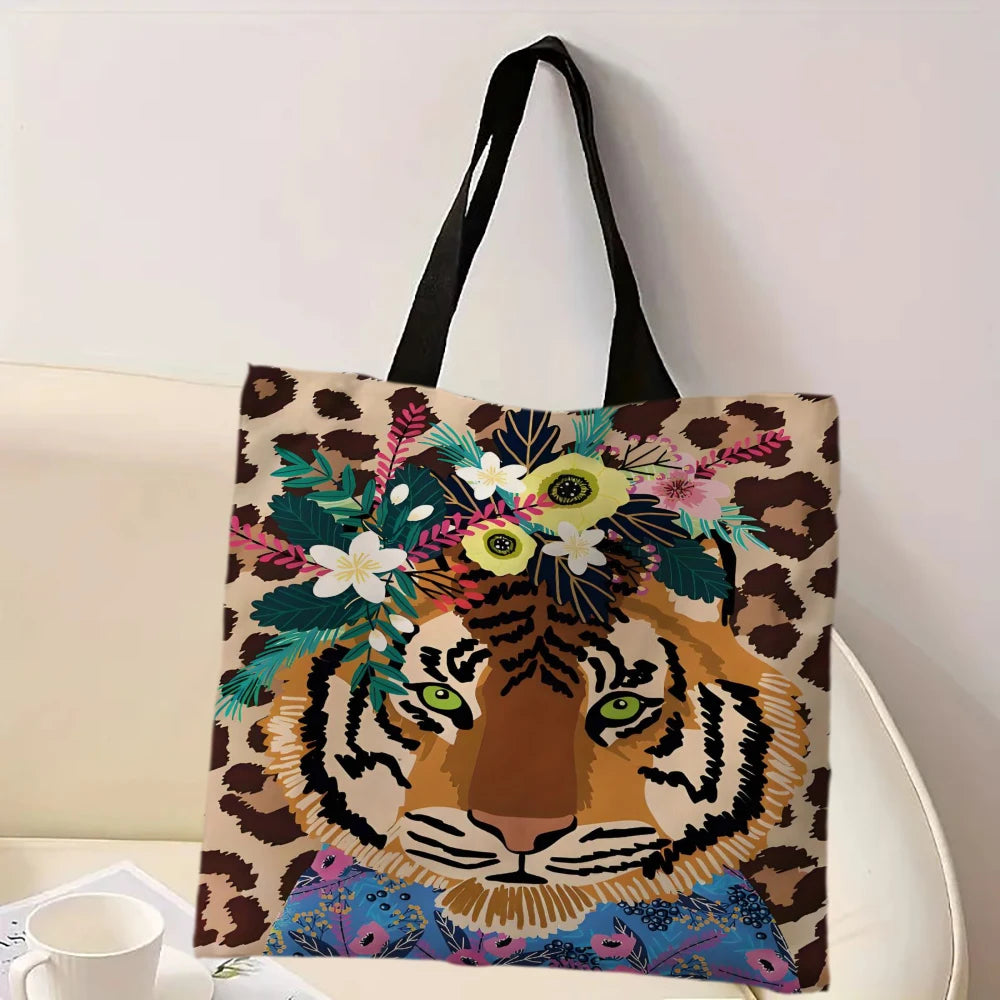 A canvas tote bag featuring an illustration of a tiger's face surrounded by a wreath of floral and foliage elements in leopar