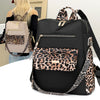 A black fashion backpack with leopard print accents and gold hardware, shown next to a person.