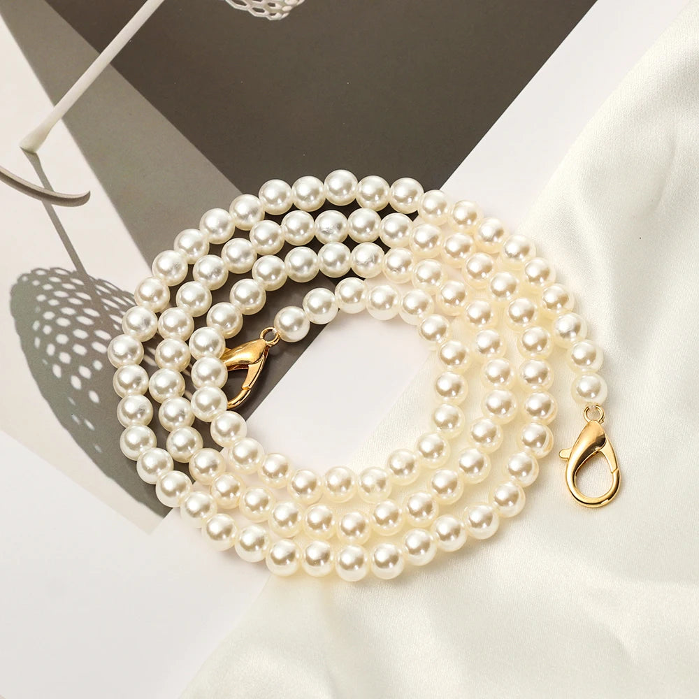 A strand of creamy white pearls used as a strap for a handbag or purse.