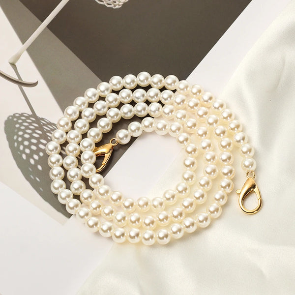A strand of creamy white pearls used as a strap for a handbag or purse.