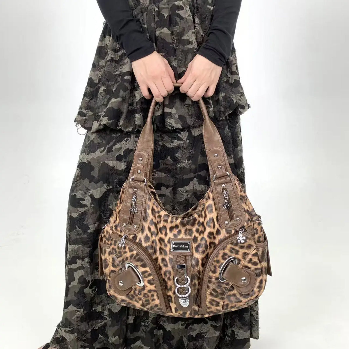 A brown leopard print crossbody shoulder bag with multiple compartments worn by a person.