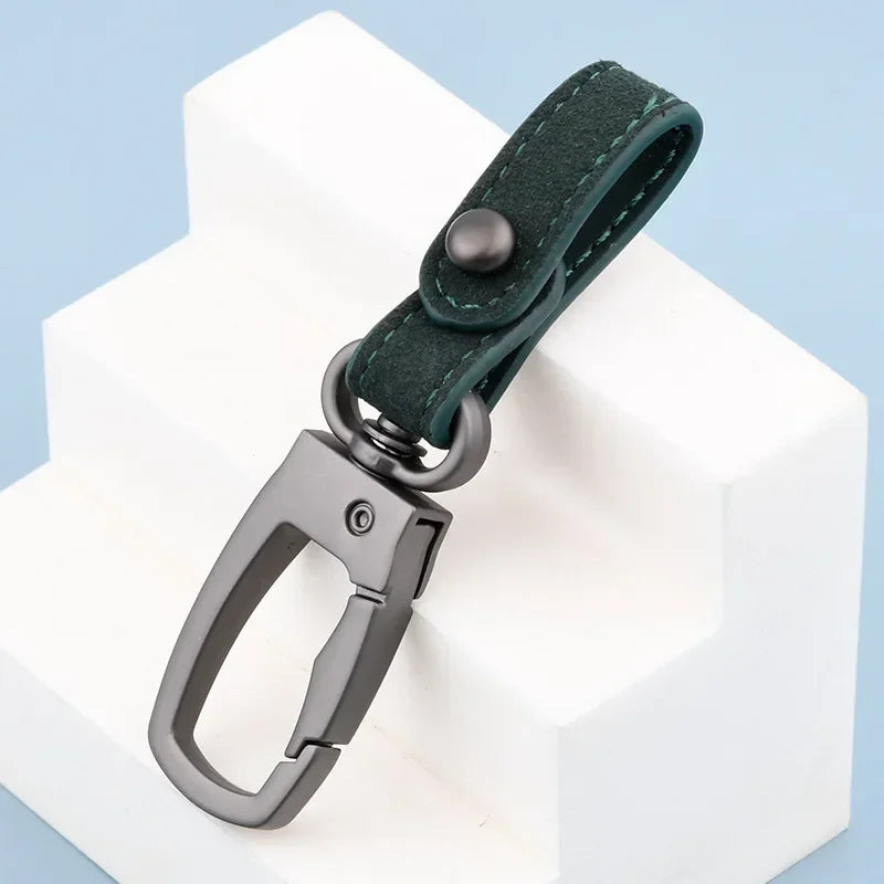 A dark green genuine leather keyring keychain attached to a white block.