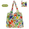 A colorful reusable shopping tote bag featuring various fruits and vegetables like apples, oranges, carrots, and leafy greens