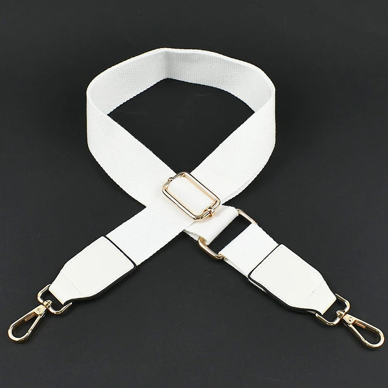 White canvas cotton bag strap with gold-toned metal hooks shown against a dark background.