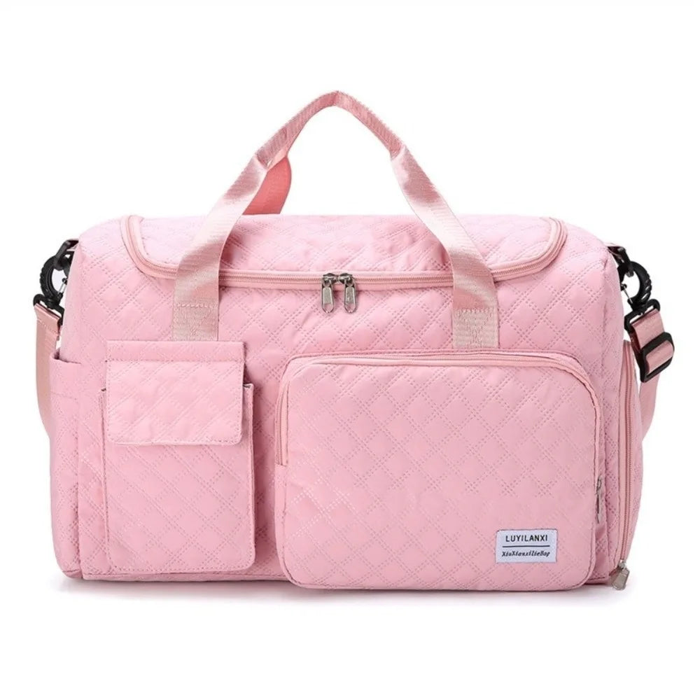 A pink quilted portable travel duffle bag with pink straps and pockets.