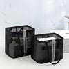 Black mesh drainage shower tote with a handle resting on a white countertop.