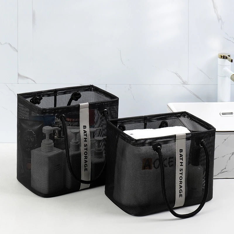 Black mesh drainage shower tote with a handle resting on a white countertop.