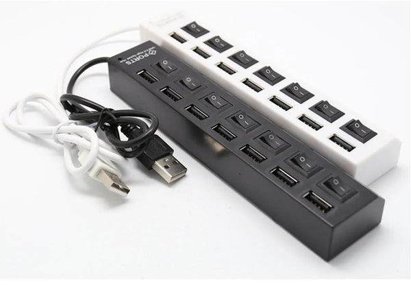A black 7-port USB splitter hub with on/off switches and a white power adapter.