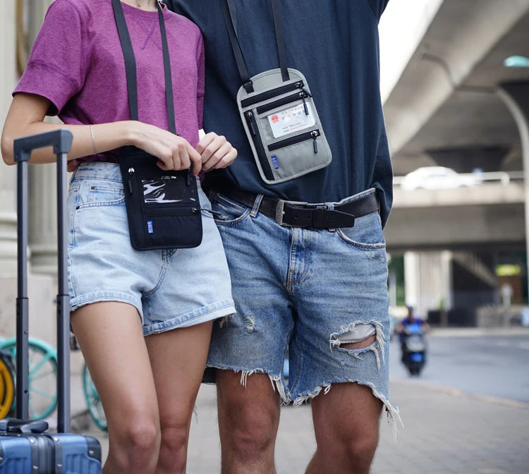 A person wearing a purple shirt and denim shorts is carrying an RFID blocking neck wallet for travel documents.