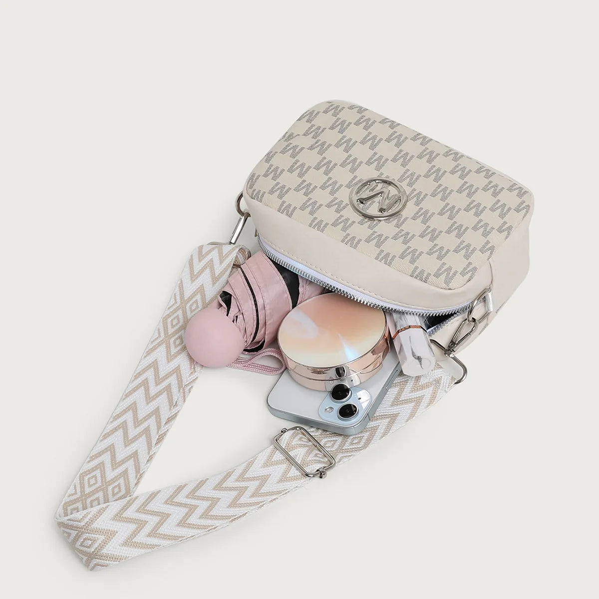 A light pink patterned crossbody bag with a beige strap and attached sunglasses.
