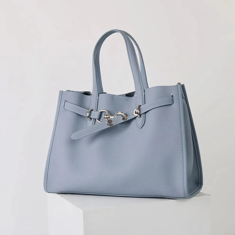 A light blue genuine leather women's shoulder tote bag with silver hardware.