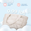 A beige quilted tote bag is shown against a light blue background with clouds, highlighting its ultimate softness and lightwe