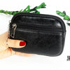Black compact PU leather mini wallet with a silver keychain being held by a hand.