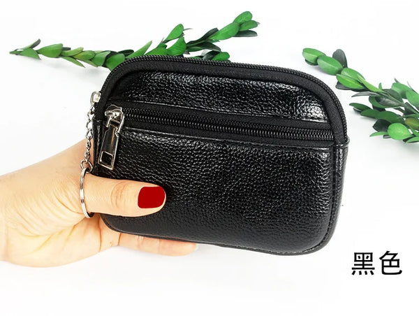Black compact PU leather mini wallet with a silver keychain being held by a hand.