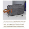 A gray toiletry cosmetics bag with brown straps shown in a studio setting.