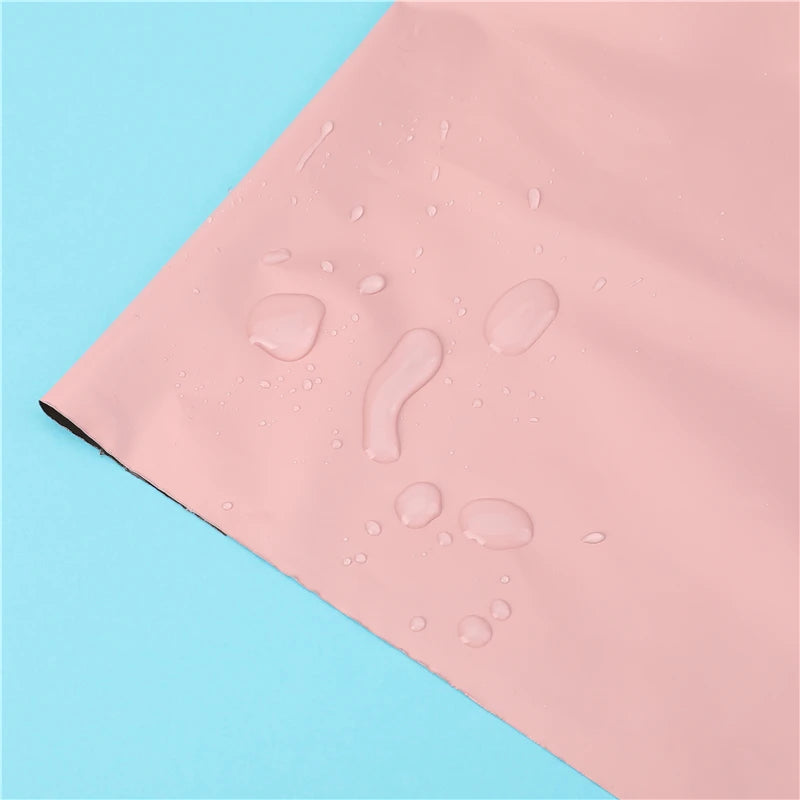 Bolsas adhesivas rosas para almacenamiento con gotas de agua sobre un fondo azul claro