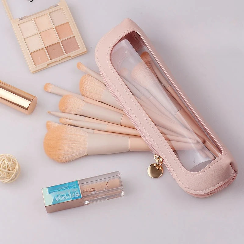 A pink cosmetic organizer pouch containing makeup brushes and a gold-colored product container.