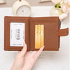 A brown leather wallet with a RFID-blocking card slot and coin pouch is held by a hand on a white surface.