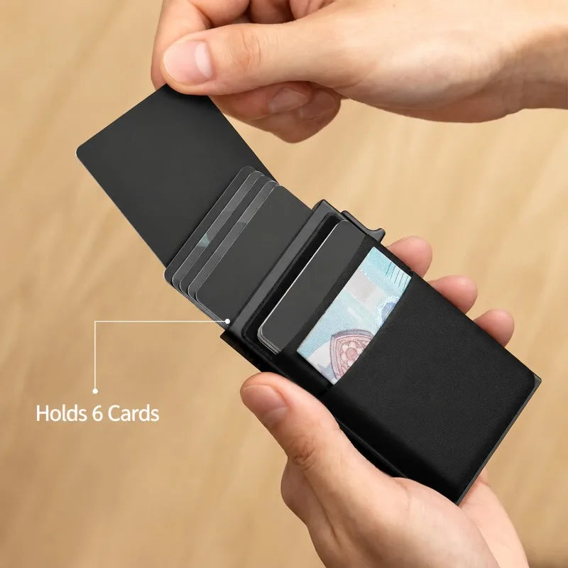 Une main tient un porte-cartes en carte pop-up métallique noir affichant six cartes.