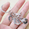 Silver keychain set featuring a cowboy boot, hat, and horseshoe charms