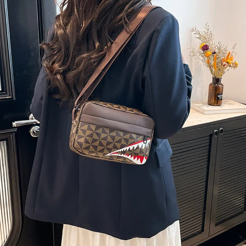 A dark navy blazer worn over a white top, featuring a brown patterned square crossbody purse with a shark tooth design.