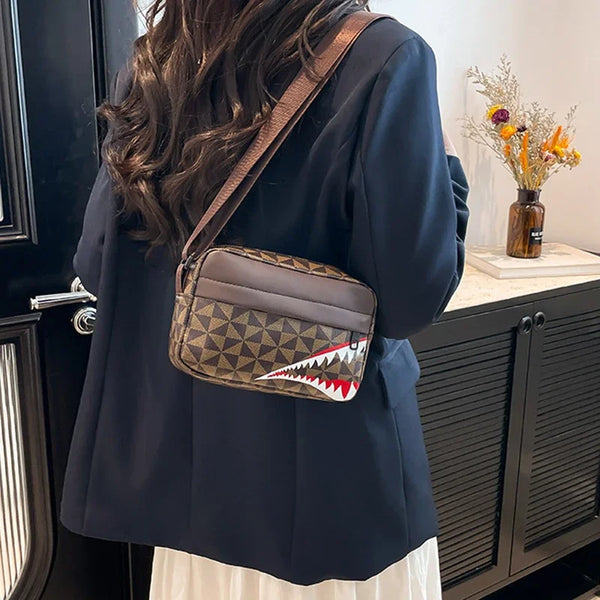 A dark navy blazer worn over a white top, featuring a brown patterned square crossbody purse with a shark tooth design.