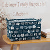 A dark blue fabric storage basket with various animal-themed patterns sits on a wooden shelf.