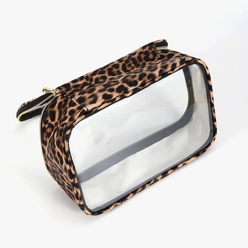 A leopard print waterproof cosmetic organizer bag with a clear plastic window and gold zipper.