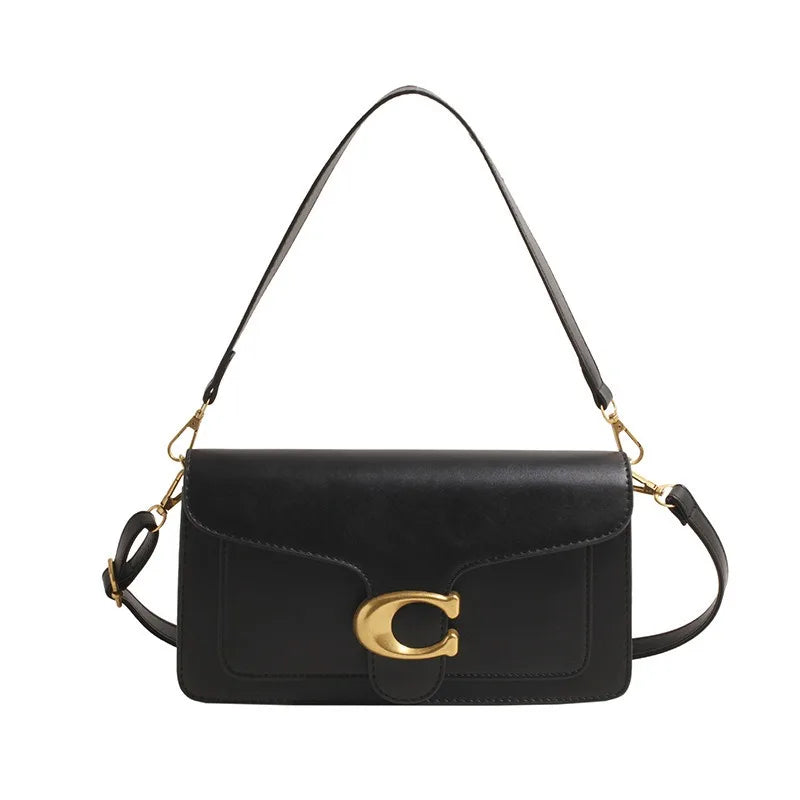 A black leather shoulder bag with gold hardware and a long strap.