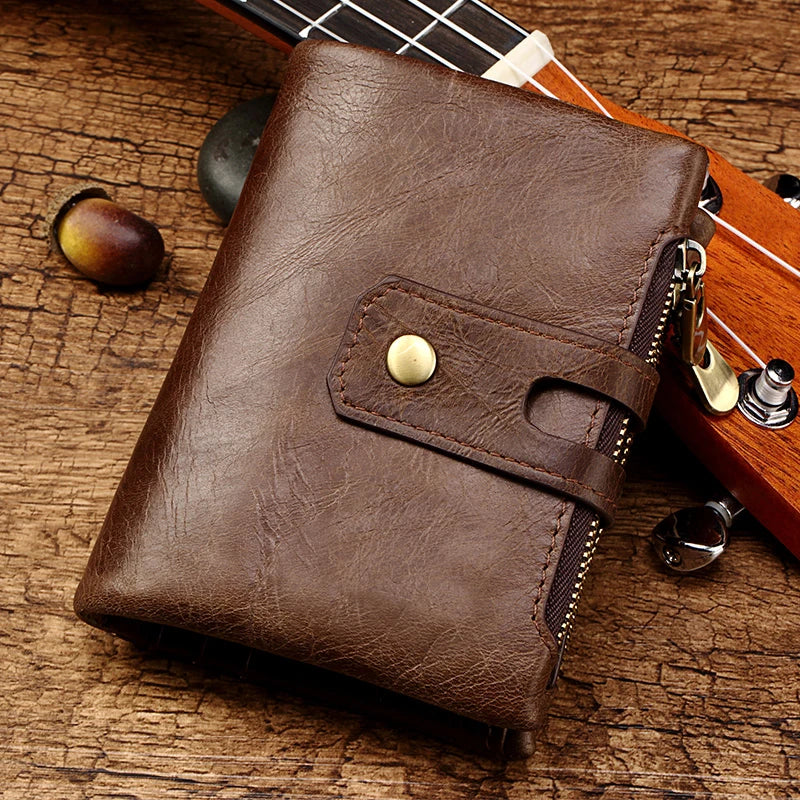 Braunes Leder-Bifold-Wallet auf Holzoberfläche neben einem Gitarrenhals.