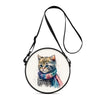 A round crossbody bag featuring a cartoon kitten design with blue and pink accents.