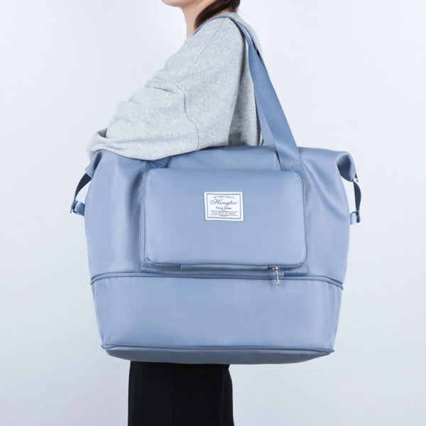 A light blue expandable travel organizer bag with a zippered pocket and shoulder straps.