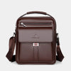 A dark brown vintage PU leather crossbody messenger bag with a top handle and flap pocket.