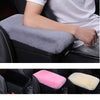 A set of plush car armrest cushions in gray, pink, and cream colors shown in a vehicle interior.