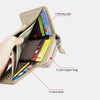 Una mano abre una cartera de cuero beige con cremallera, mostrando varios compartimentos como para dinero, monedas y seis tar