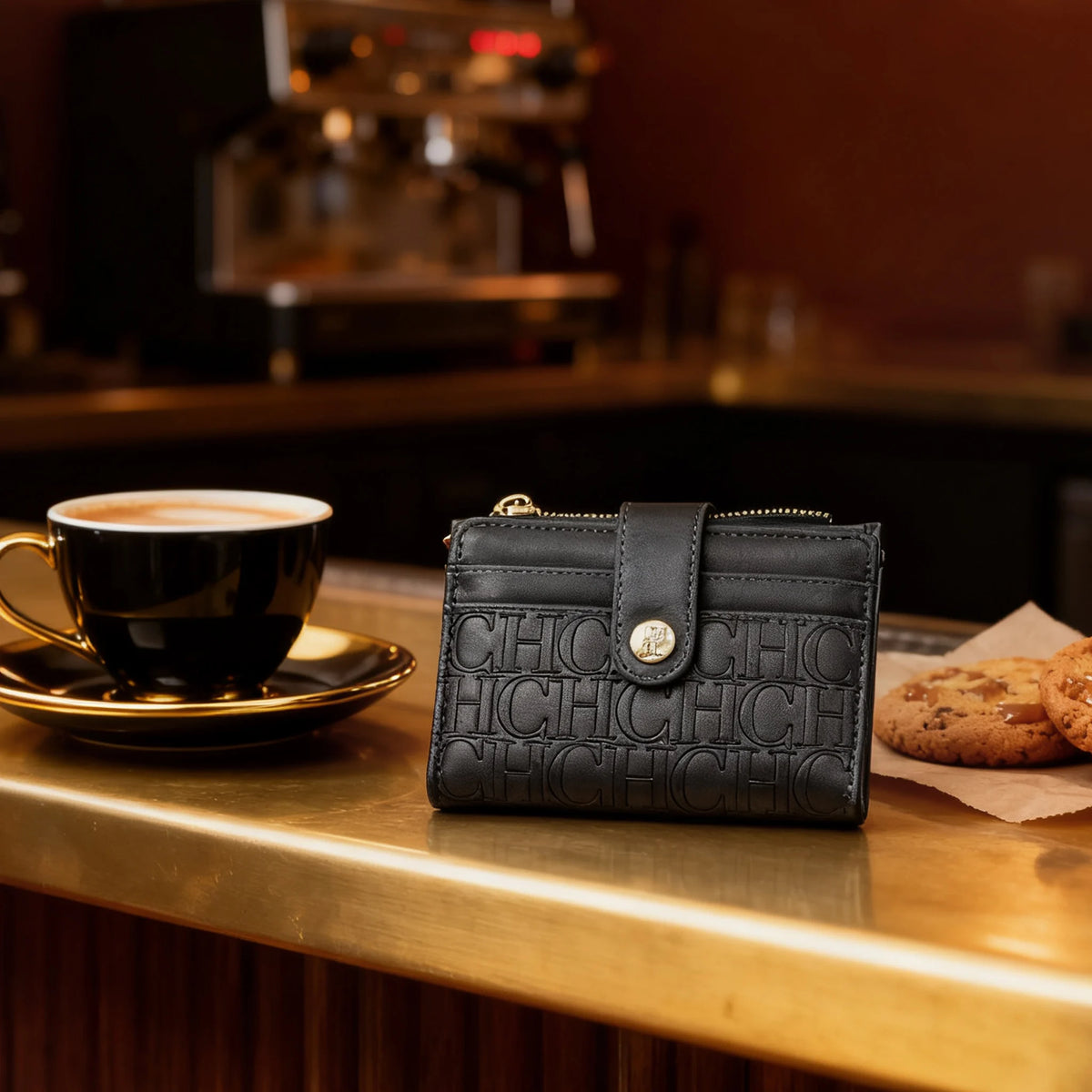 A black leather square folding wallet rests on a wooden counter next to a cup of coffee.