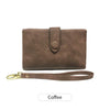 A brown leather card wallet with a flap and a matching leather strap.