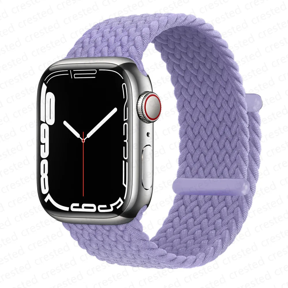 A silver Apple Watch is shown on a purple braided stretch band.