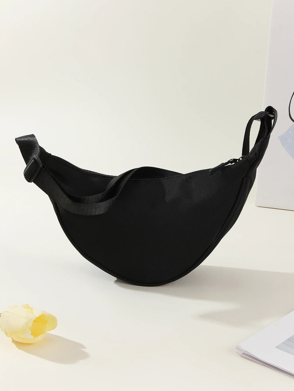 Black women's preppy sling crossbody bag displayed on a white surface.