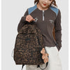 A young woman wearing a brown long-sleeved shirt and white pants is carrying a leopard print backpack.
