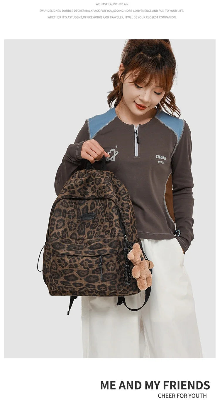 A young woman wearing a brown long-sleeved shirt and white pants is carrying a leopard print backpack.