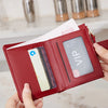A close-up of a red PU leather bifold wallet with a zipper closure showing an ID card and credit cards.